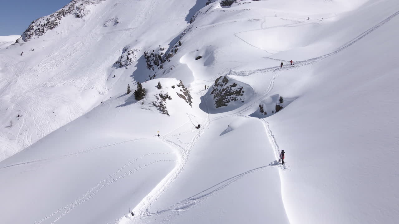 Aerial view of a person skiing down powder snow slopes of the wintry alpines