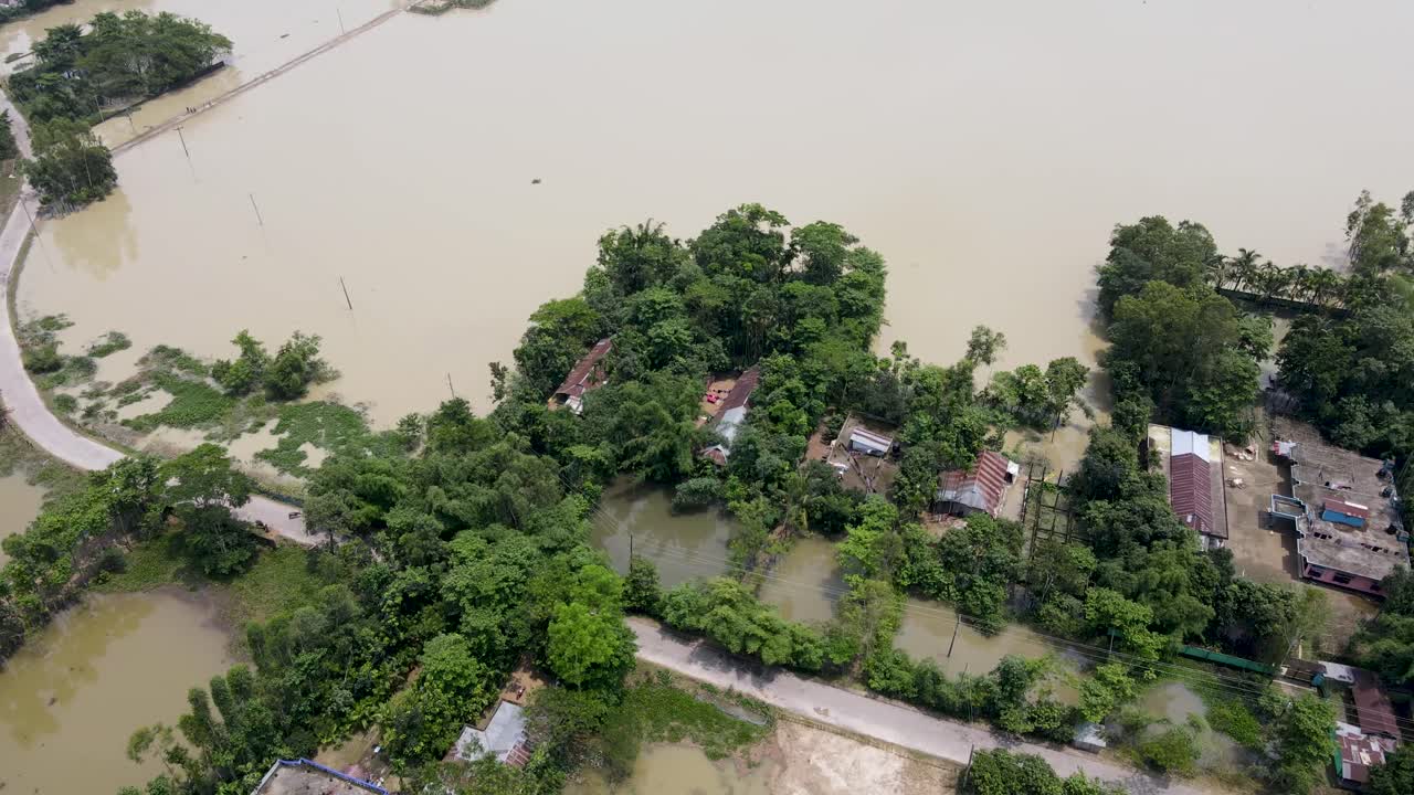 Aerial view of flooded village with submerged road, home and trees in Bangladesh, South Asia