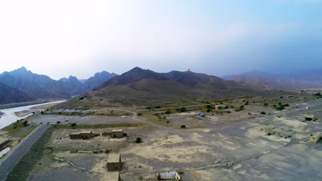 Zooming-out-from-the-majestic-mountains,-Roads-and-houses-near-the-hill