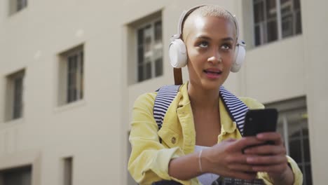 Mujer-De-Raza-Mixta-Escuchando-Música-En-La-Calle-En-Su-E-Scooter