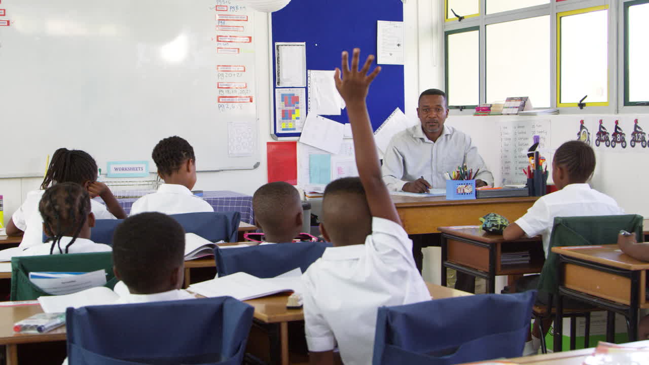 el maestro comprueba la lista de asistencia en la clase de escuela primaria