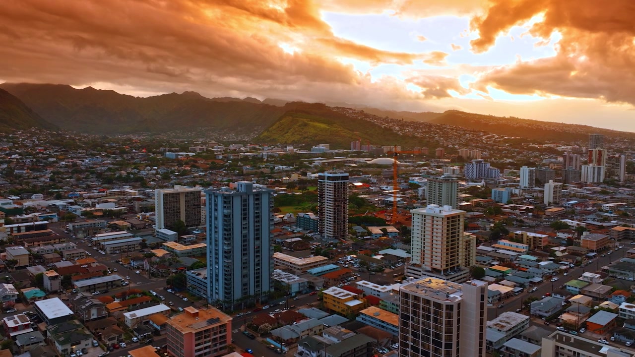 Mozzafiato cielo nuvoloso arancione sopra il paesaggio urbano di Honolulu, Hawaii, USA. Splendido scenario della città al tramonto. Vista aerea