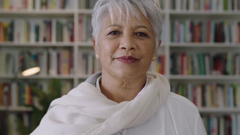 portrait-of-confident-friendly-indian-middle-aged--teacher-standing-in-library-close-up