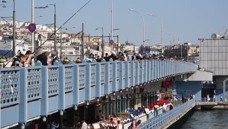 people fishing from galata bridge in istanbul, turkey