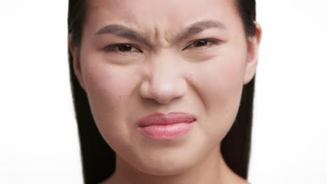 close-up of a woman grimacing with a look of disgust