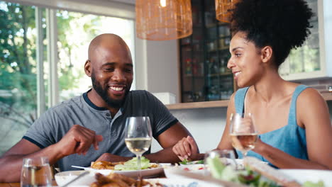 Pareja-Sentada-Alrededor-De-La-Mesa-En-Casa-Disfrutando-De-Una-Comida-Con-Vino-Juntos