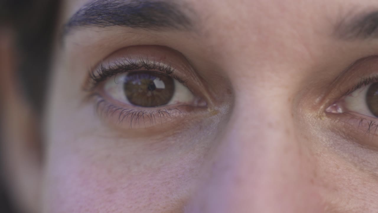 fotografía macro de los ojos de una mujer caucásica marrón abriéndose y sorprendiendo, de cerca