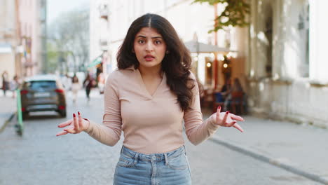 surprised frustrated indian woman raising hands asking reason of failure, demonstrating disbelief