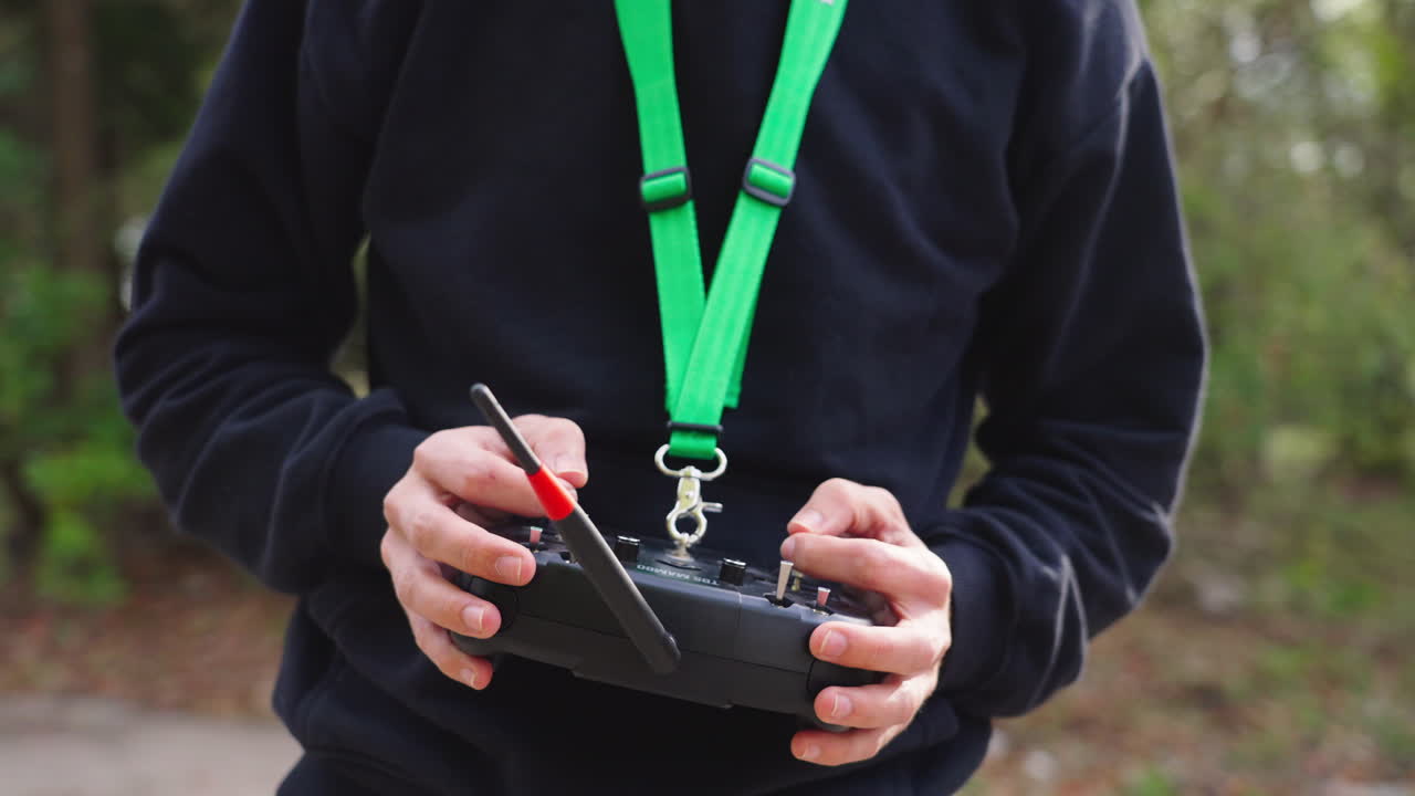 Pilot drona FPV sterujący aparaturą w goglach na zewnątrz