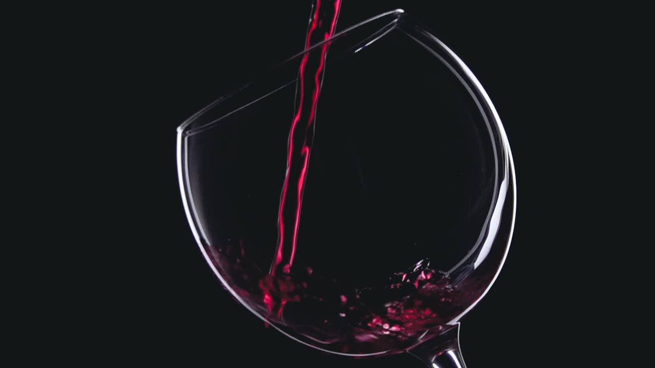 Red wine in wineglass on black background