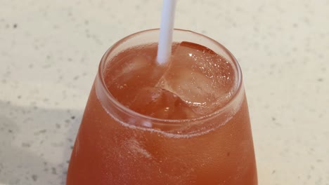 agitando a mano el ponche rojo con una pajita