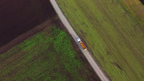 vista aérea de la conducción de camiones cargados en la carretera nacional a través de campos cultivados