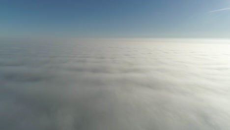 flight over misty clouds in morning sunlight with little glory and city scape under clouds