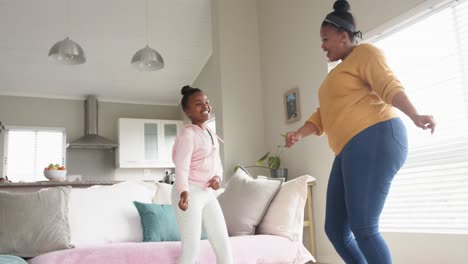 Glückliche-Afroamerikanische-Mutter-Und-Tochter,-Die-Spaß-Beim-Tanzen-Im-Wohnzimmer-Haben,-In-Zeitlupe