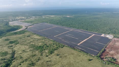 vista aérea de paneles solares que producen energía en el campo verde, parque solar fotovoltaico cumayasa en la república dominicana - toma de avión no tripulado