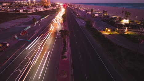 La-Autopista-De-La-Costa-Del-Pacífico-En-El-Condado-De-Orange,-Huntington-Beach-Durante-La-Puesta-De-Sol-En-Este-Impresionante-Lapso-De-Tiempo-De-Drones,-Que-Muestra-Los-Colores-Cambiantes-Y-Las-Rayas-De-Luz-De-Los-Autos