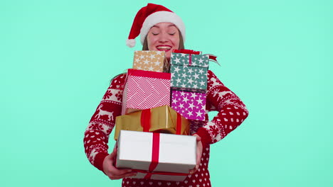 Girl-in-Christmas-red-sweater,-Santa-hat-smiling,-holding-many-gift-boxes-New-Year-presents-shopping