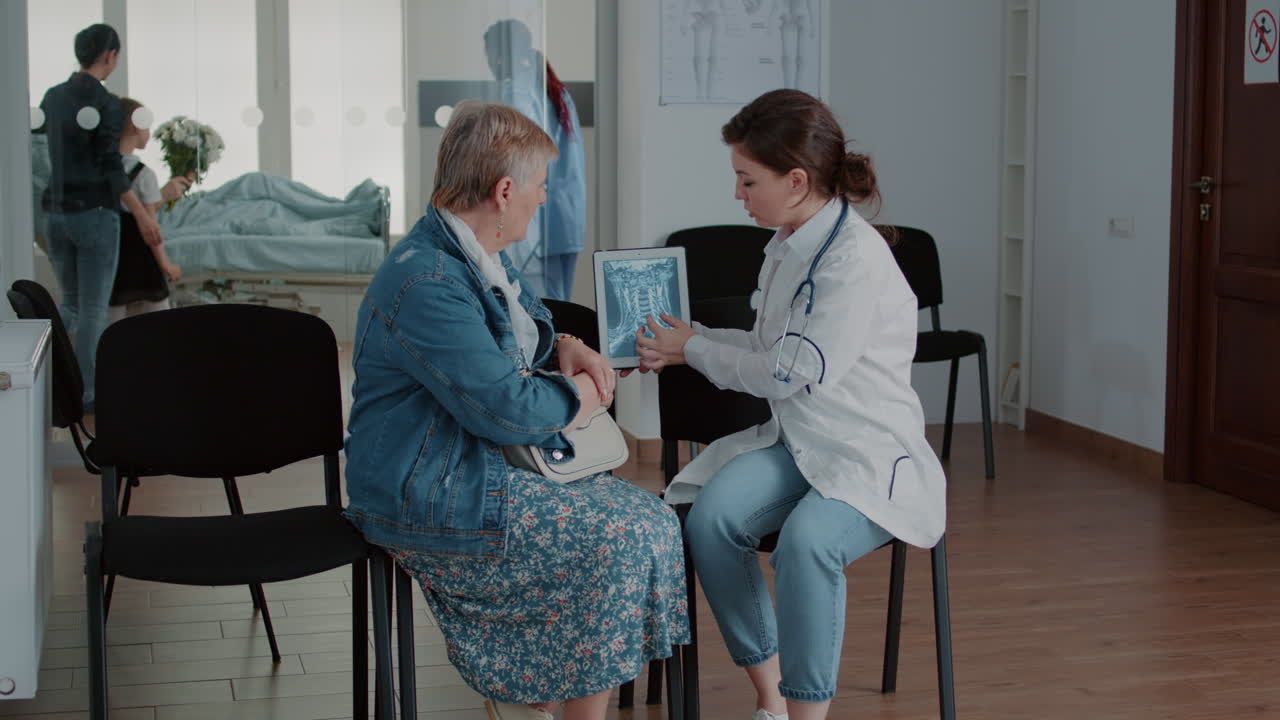 Doctor showing radiography scan on tablet to old patient
