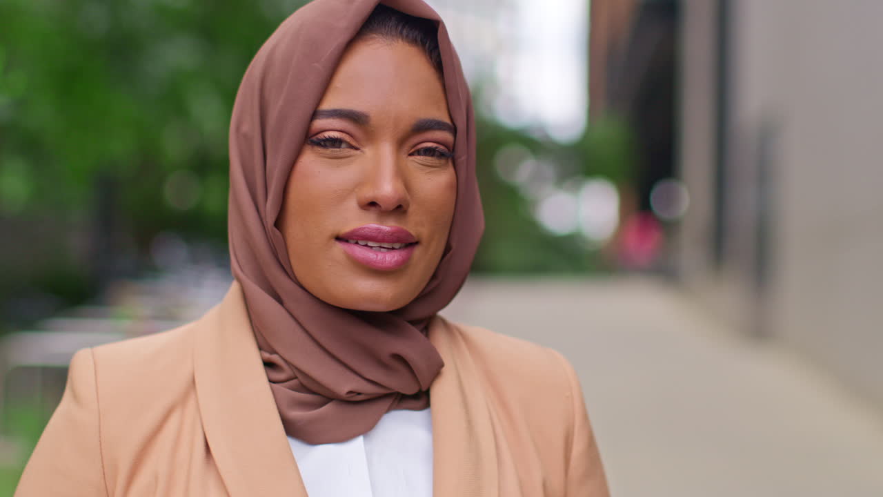 Portrait Of Smiling Muslim Businesswoman Wearing Hijab With Business Suit Going To Work Standing Outside Modern Office Buildings