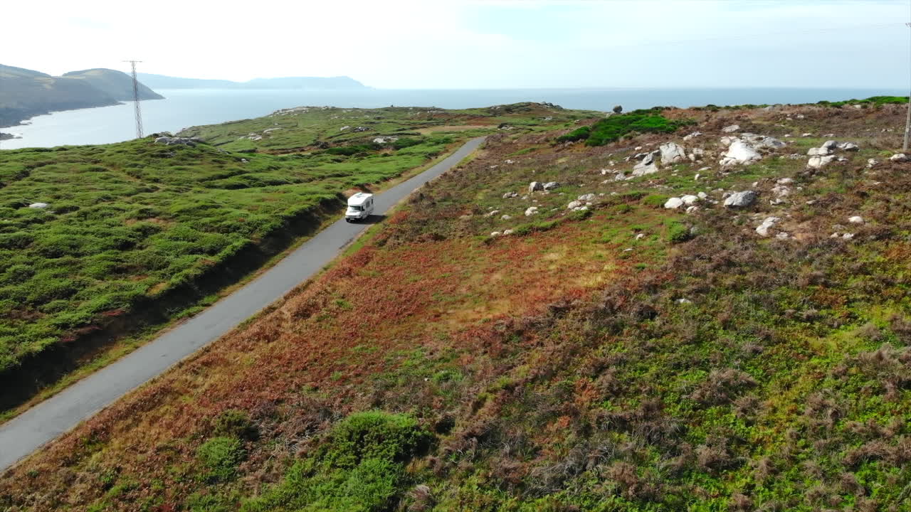Campervan driving along a scenic coastal road