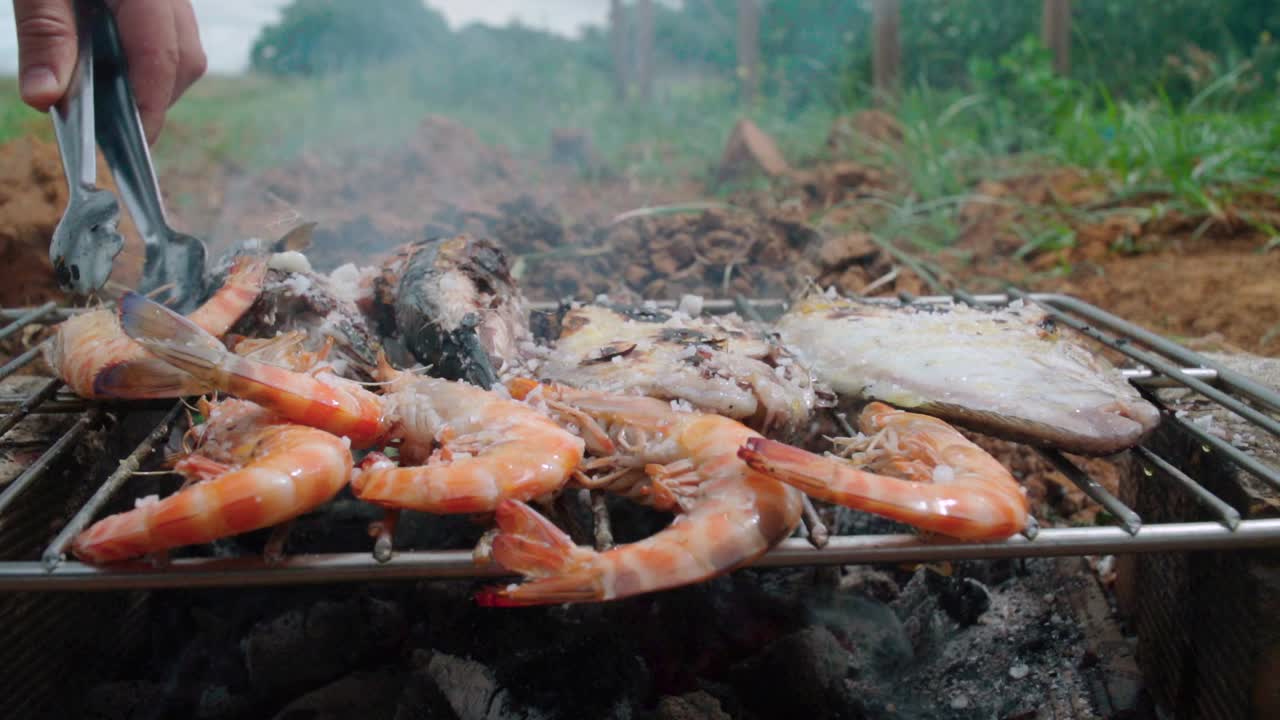 volviendo camarones en una rustica parrilla de barbacoa de madera improvisada en españa, cámara lenta