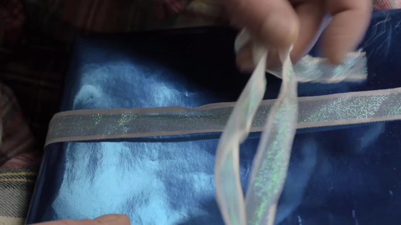 Hand opening gift wrapped in paper close up