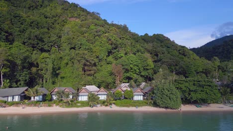 Amazing-aerial-top-view-flight-Huts-Resort-Beach-Bungalows,-Jungle-hilly-Island-Thailand-2022