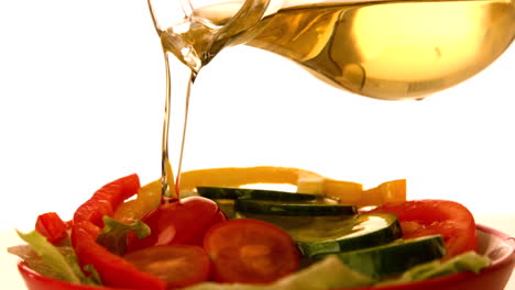 olive oil pouring over fresh salad