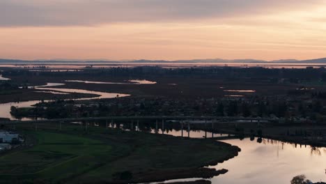 Drohnen-Luftaufnahme-Eines-Highways,-Der-Bei-Sonnenuntergang-Nach-Napa,-Kalifornien-Hinein-Und-Wieder-Hinaus-Führt