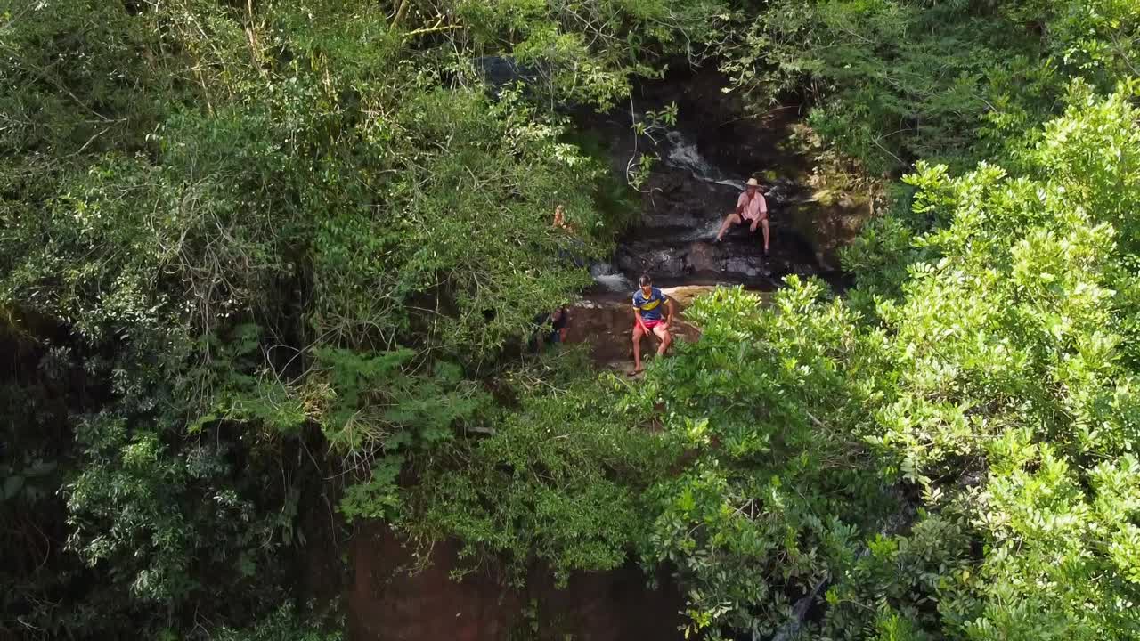 Up pan shot of Water Falls In Misiones, Argentina. Waterfalls In South America with People Relaxing. Aerial Drone Shot.