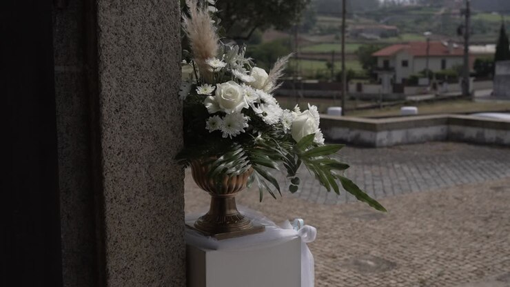 Rose bianche e vegetazione in un vaso che decora il luogo del matrimonio