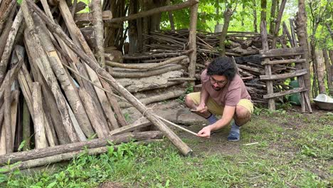 A-man-try-to-cut-branch-tree-working-with-crescent-blade-agriculture-hand-tool-to-cut-wood-stick-tree-branches-in-clean-in-sharp-with-steel-metal-wooden-handheld-handle-rural-area