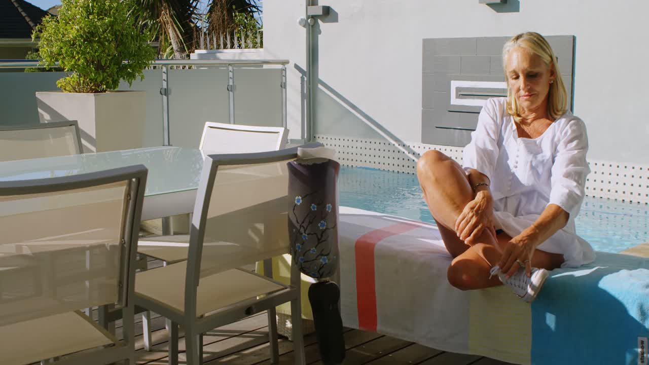 mujer discapacitada quitando los zapatos en el balcón 4k