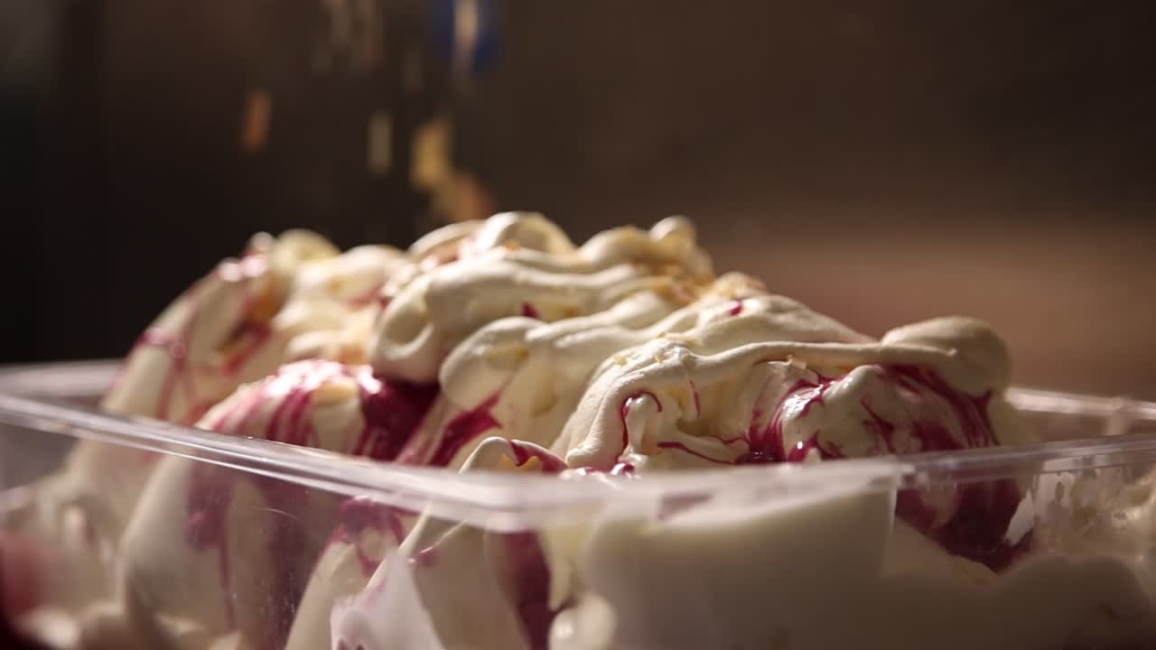 Primo piano di granella di frutta secca che cade su gelato variegato