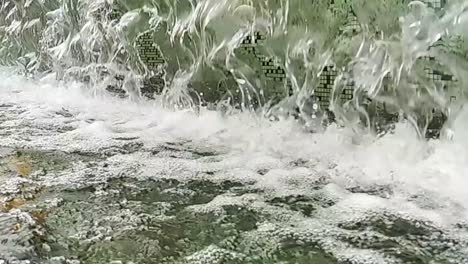 Close-up or fountain water drops to small pool in the city