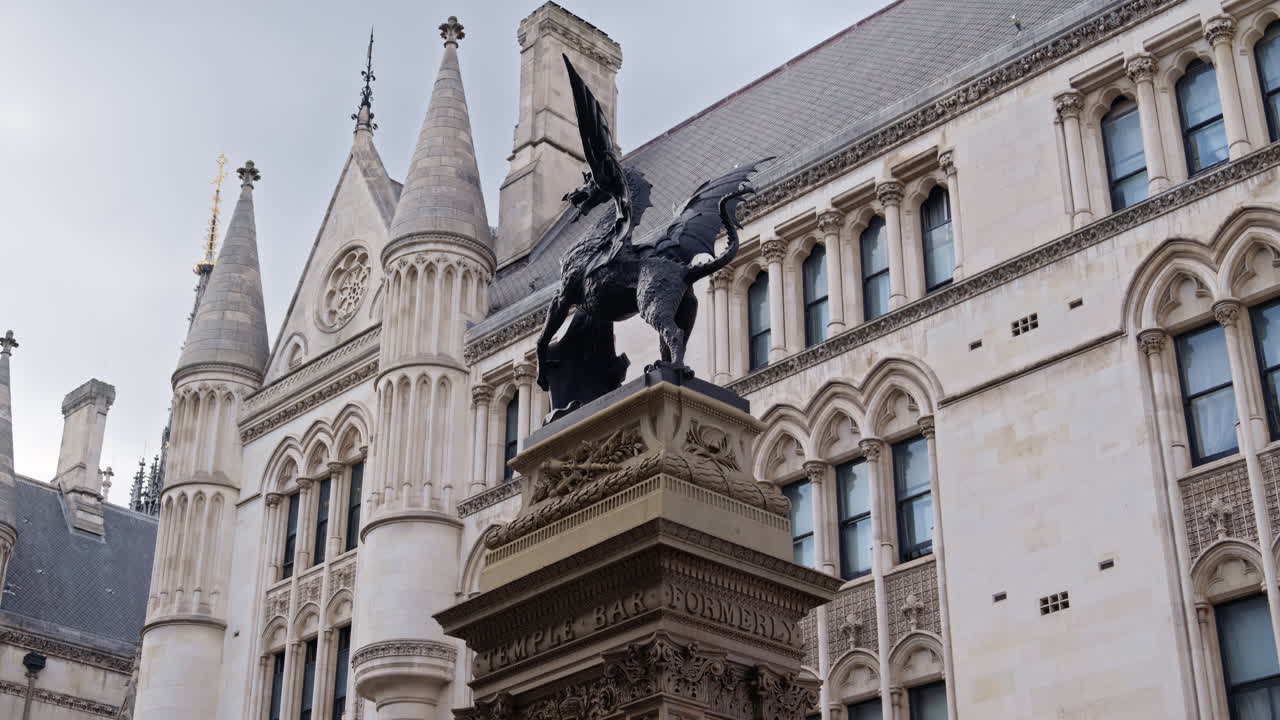 Close up of the Temple Bar dragon statue and intricate Gothic architecture of the Royal Courts of Justice, London, England
