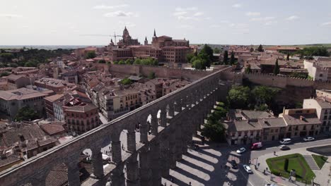 aqueduct bridge over plaza del azoguejo surrounded by city landscape on clear sunny day