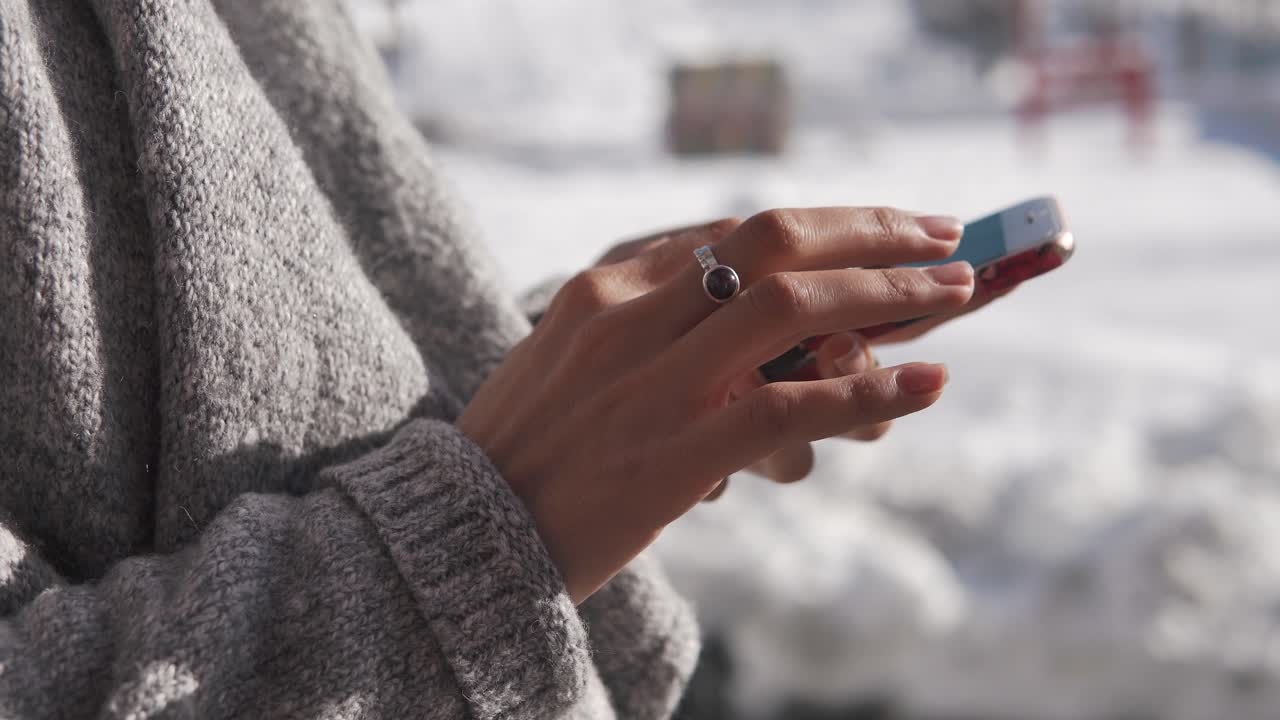 Donna che usa uno smartphone all'aperto in inverno
