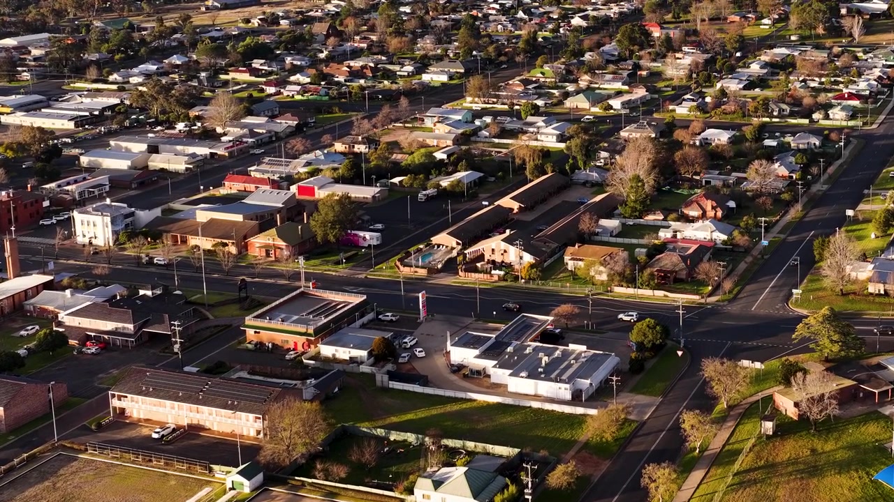 Ripresa aerea con drone dall'alto di una tranquilla città australiana con case residenziali e alberi verdi