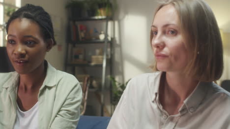 two diverse women having a conversation and sharing a smile indoors