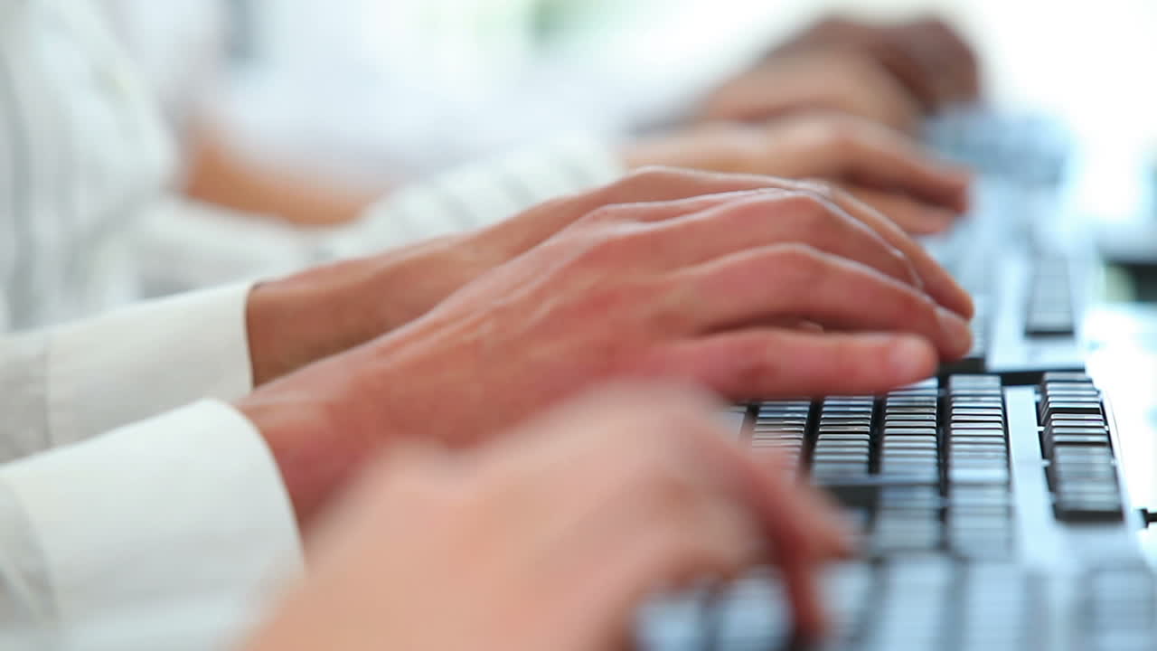 Close up of people typing on keyboards