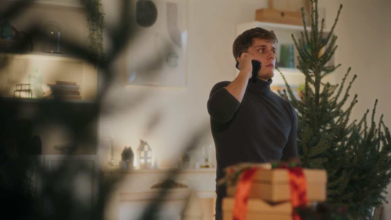 집에서 스마트폰으로 전화하려고 하는 남자