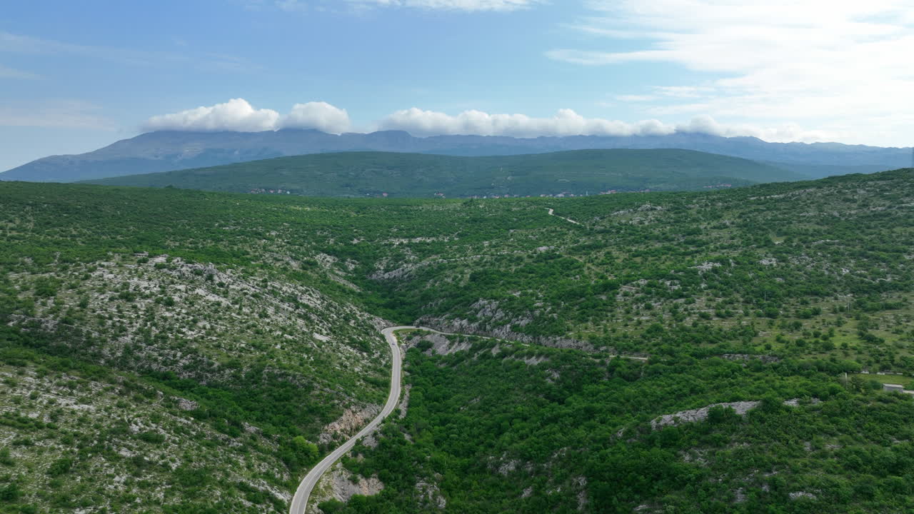 un vuelo de avión no tripulado sobre el camino sinuoso que sube a la montaña