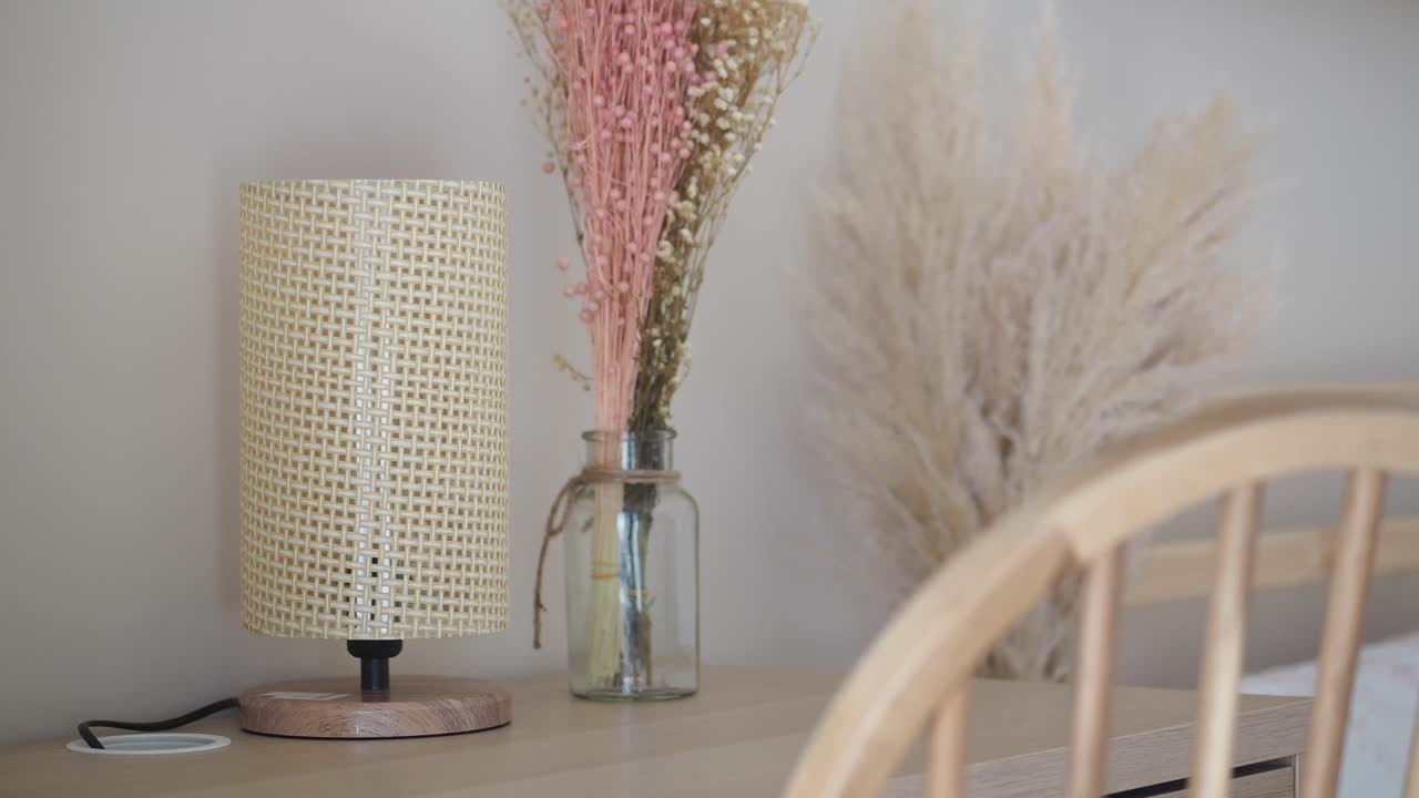 Aménagement de bureau douillet avec lampe tressée et fleurs séchées