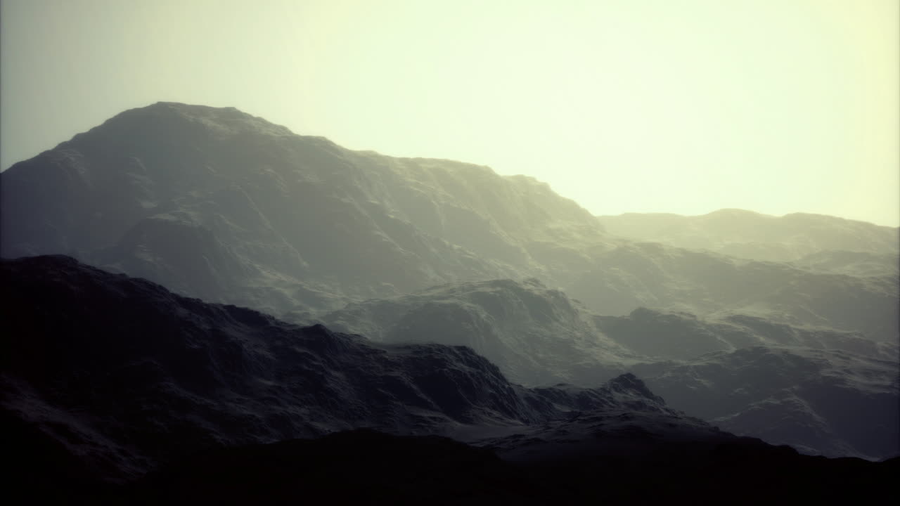 Mysterious mountain ranges under soft hazy light at dawn