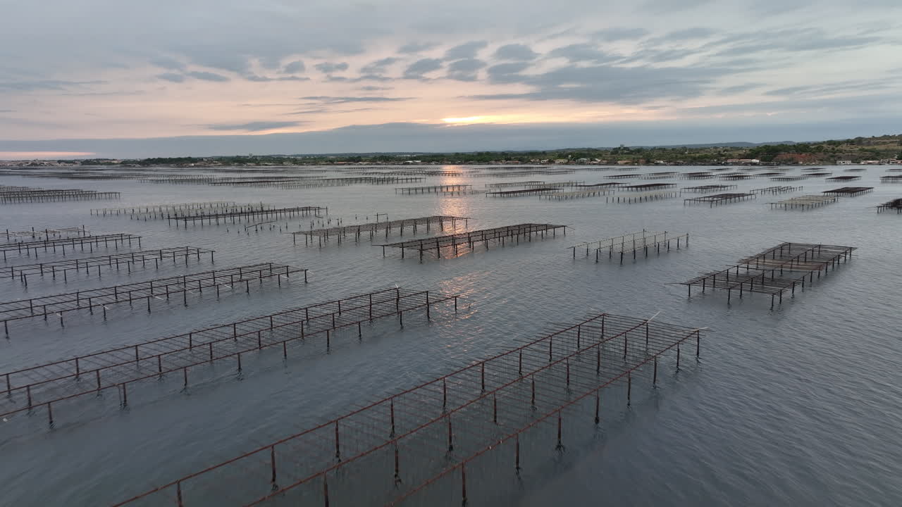 la puesta de sol sobre etang de thau ofrece una vista impresionante de su cultivo de ostras desde