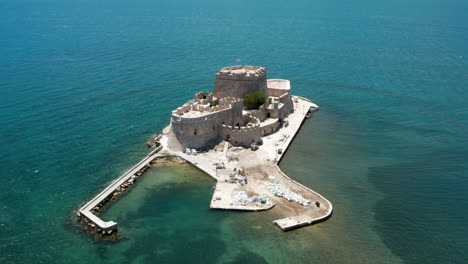 Vista-Aérea-De-La-Fortaleza-De-Bourtzi-Junto-Al-Tranquilo-Mar-Azul-En-Nafplio,-Grecia