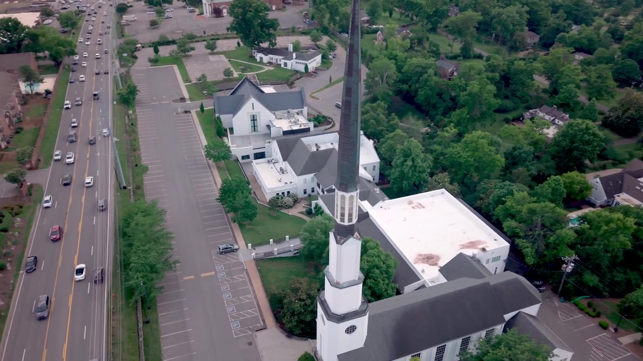 La Chiesa Cristiana e Scuola Materna Woodmont a Nashville, Tennessee, con il suo alto campanile bianco, il vasto campus e i dintorni alberati - orbita aerea
