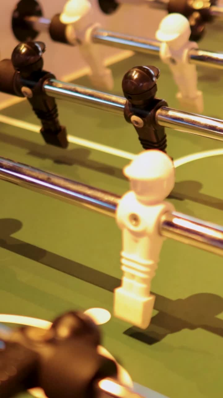 los jugadores participan en un animado partido de futbolín