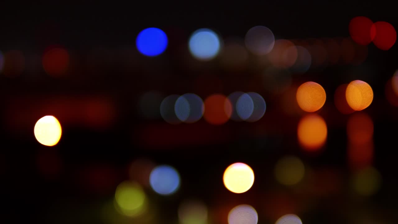bokeh de fondo de rascacielos en la ciudad con luces y círculos de colores borrosos en la noche